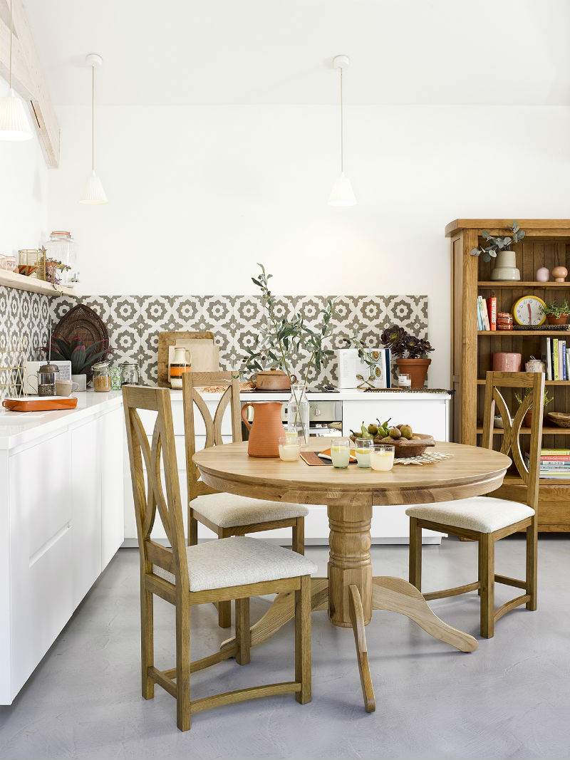 a kitchen with round dining table and bookcase