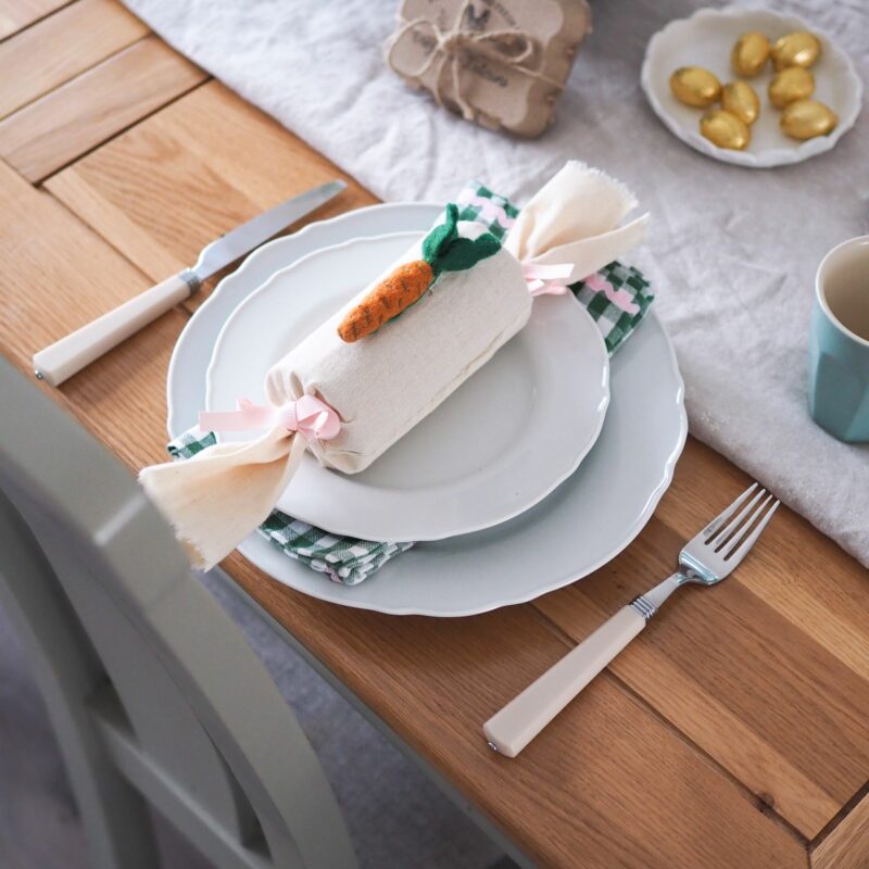 Oak Furnitureland dining table set for Easter, with homemade fabric Easter cracker and gold eggs.