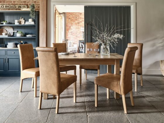 A kitchen table and chairs-kitchen dining furniture-extendable wooden table-tan leather effect seats-stone floor-dark blue dresser