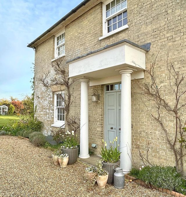 Laura Sunderland's beautiful period property with a pale blue door and potted plants.