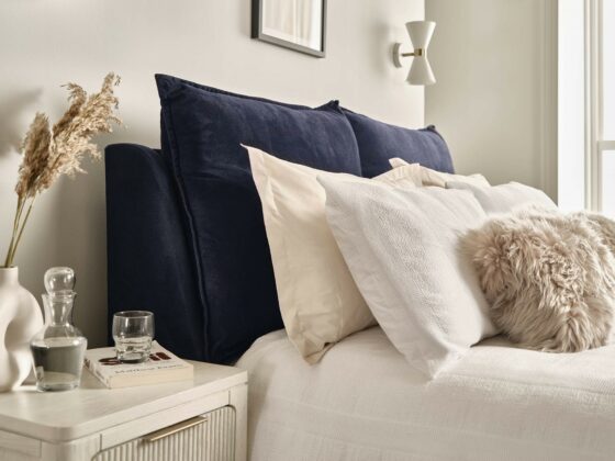 A bed and bedside table-bedroom furniture-upholstered blue king-size bed-wooden bedside table with drawers-layered bedding