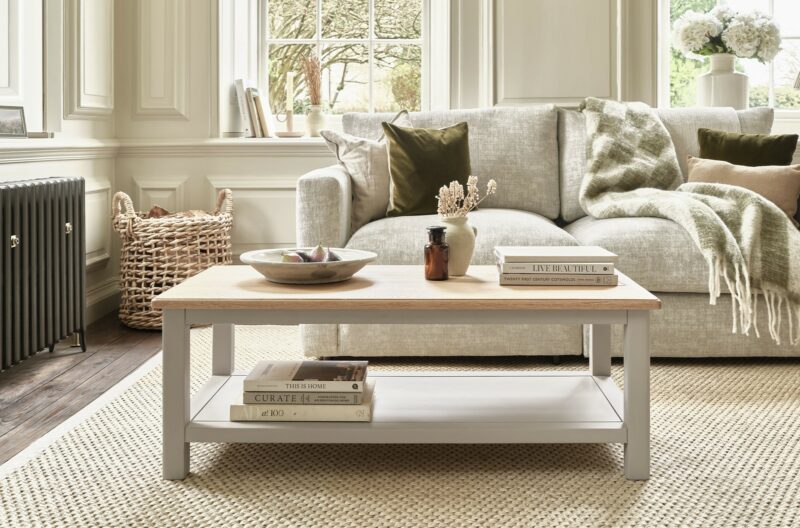 A coffee table and sofa-living room furniture-wooden coffee table painted neutral-neutral walls-neutral 2-seater sofa