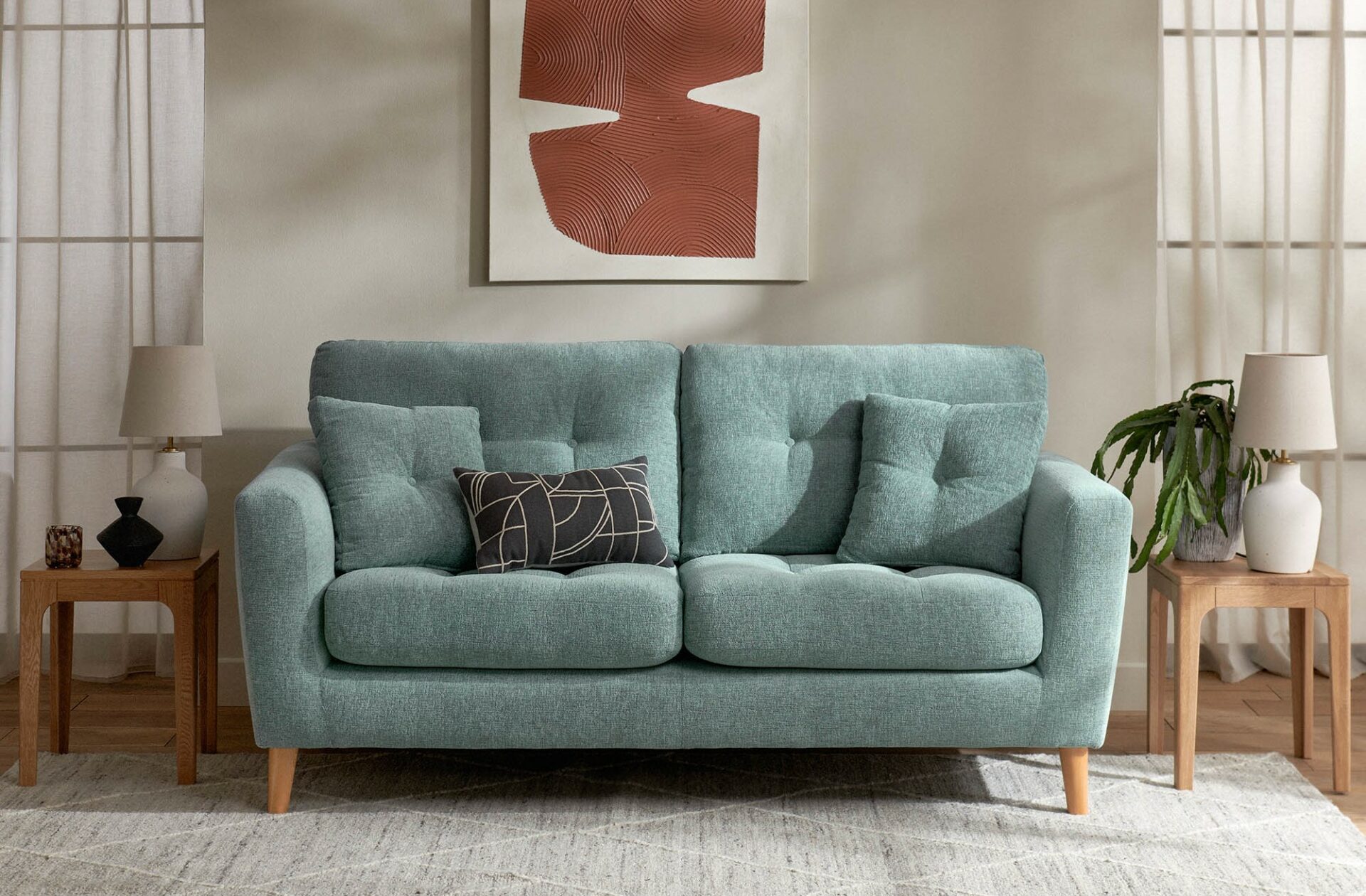 A sofa and side tables-living room furniture-duck egg blue sofa-patterned charcoal cushion-oak nest of tables-textural wall art-grey rug-mid-century style-neutral walls