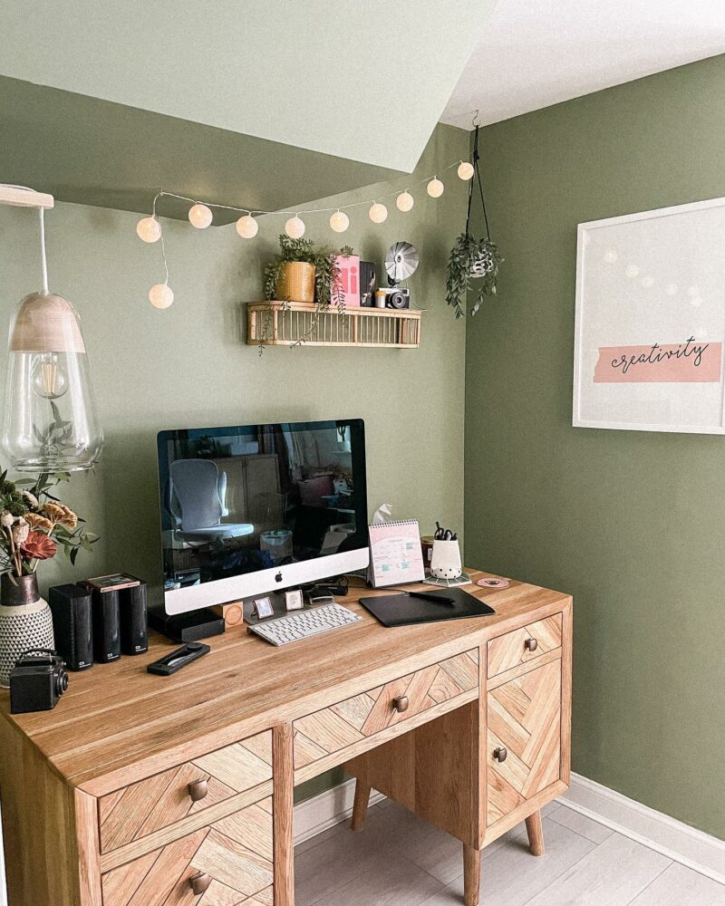 Oak Furnitureland Parquet desk in a muted green home office with string lights and white wall art.