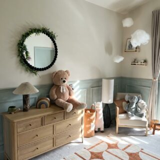 A chest of drawers-nursery furniture-wooden chest of drawers-cuddly toys-patterned rug-panelled walls