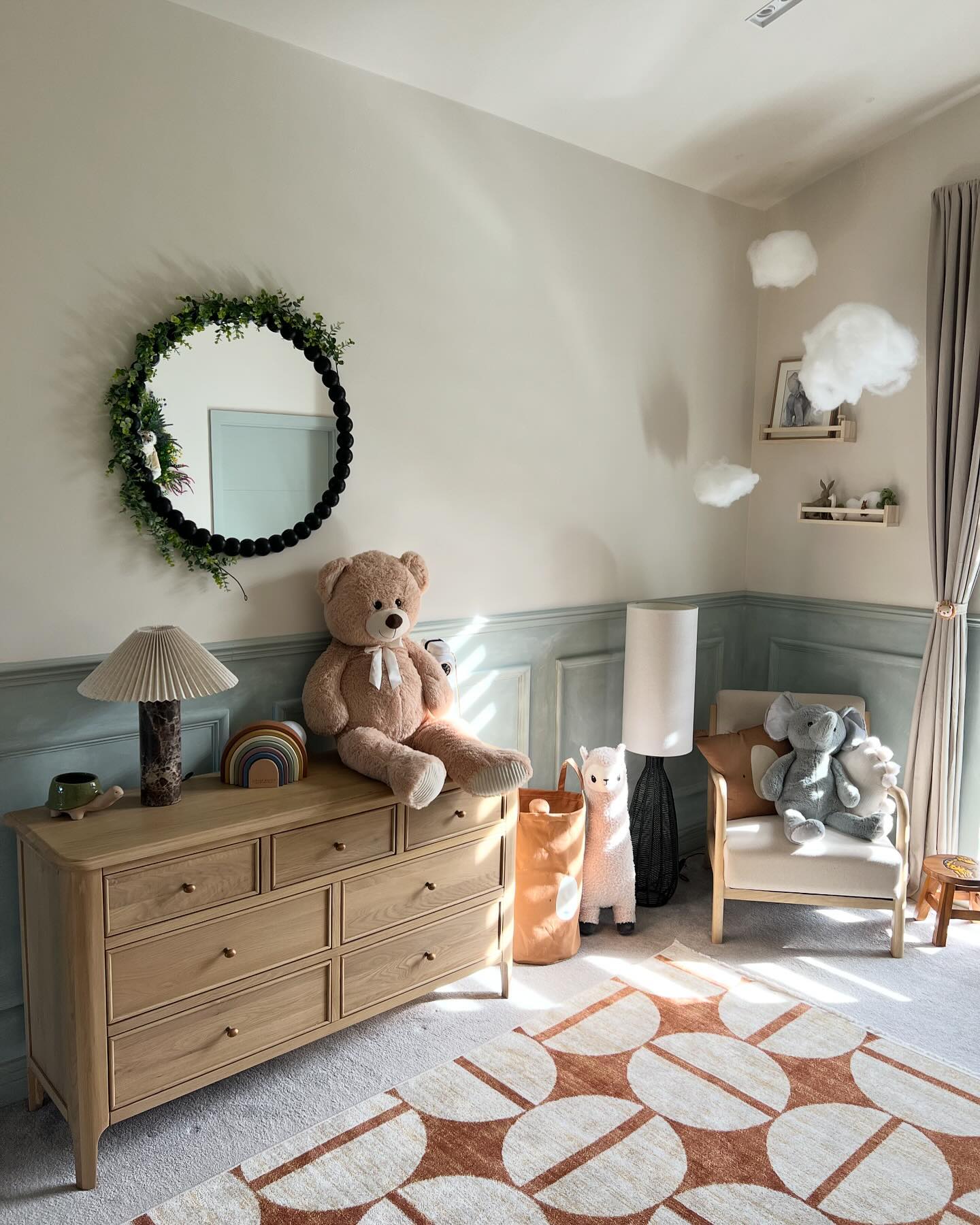 A chest of drawers-nursery furniture-wooden chest of drawers-cuddly toys-patterned rug-panelled walls